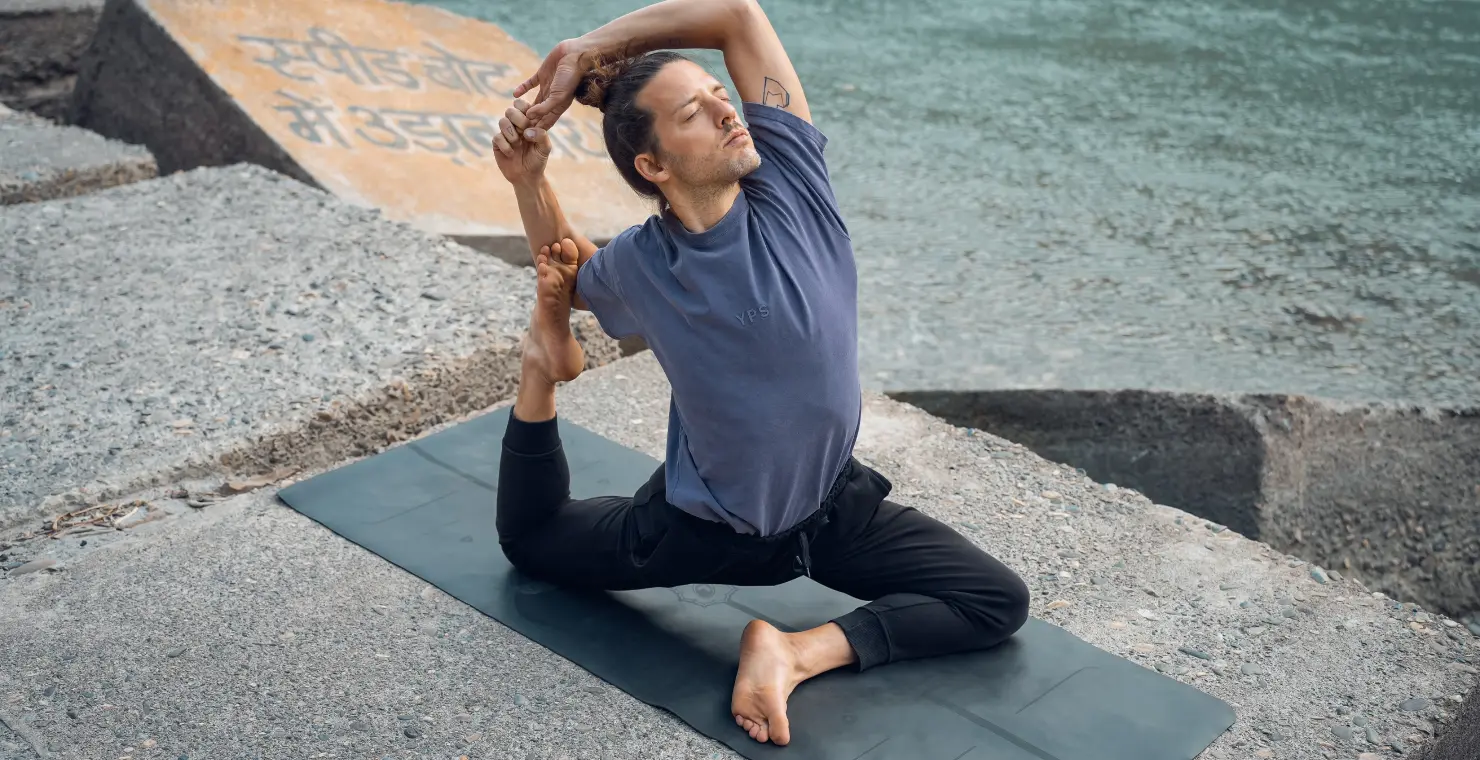 A practitioner doing yoga pose outdoors during morning session in Rishikesh